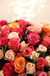 Beautiful bouquet of colorful roses on beige background, closeup