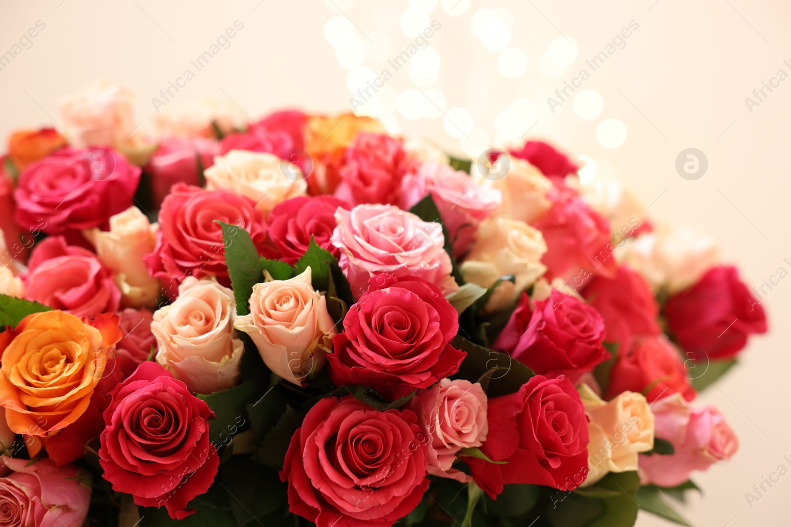 Photo of Beautiful bouquet of colorful roses on beige background, closeup