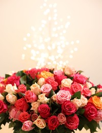 Photo of Beautiful bouquet of colorful roses on beige background