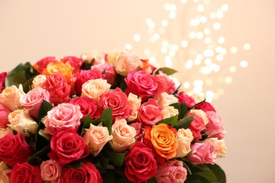 Photo of Beautiful bouquet of colorful roses on beige background