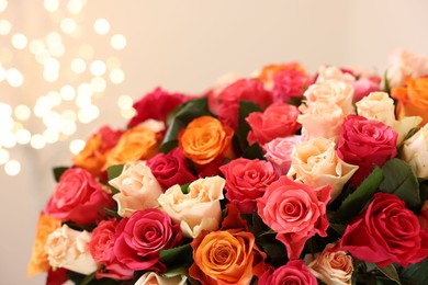 Photo of Beautiful bouquet of colorful roses on beige background, closeup