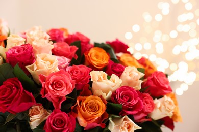 Photo of Beautiful bouquet of colorful roses on beige background, closeup