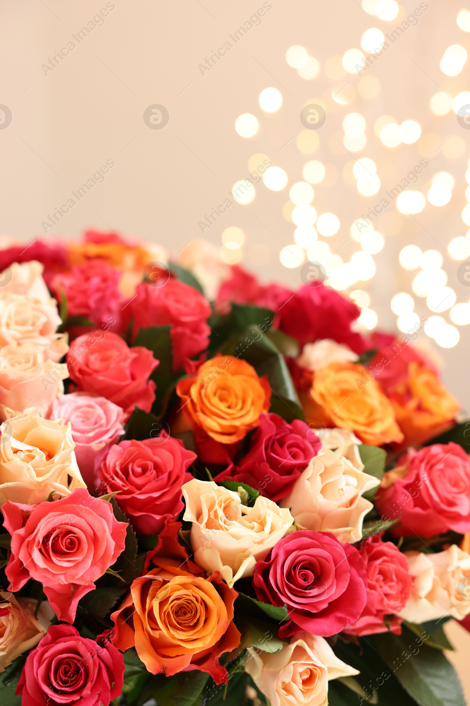 Photo of Beautiful bouquet of colorful roses on beige background