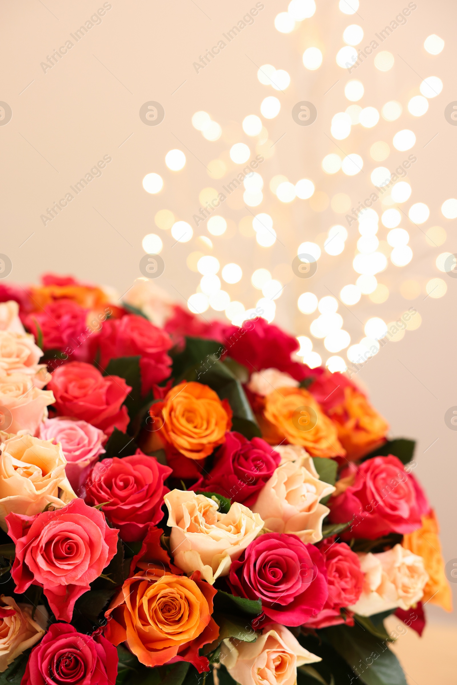 Photo of Beautiful bouquet of colorful roses on beige background