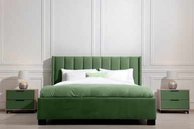 Image of Comfortable sage green bed in room. Interior design