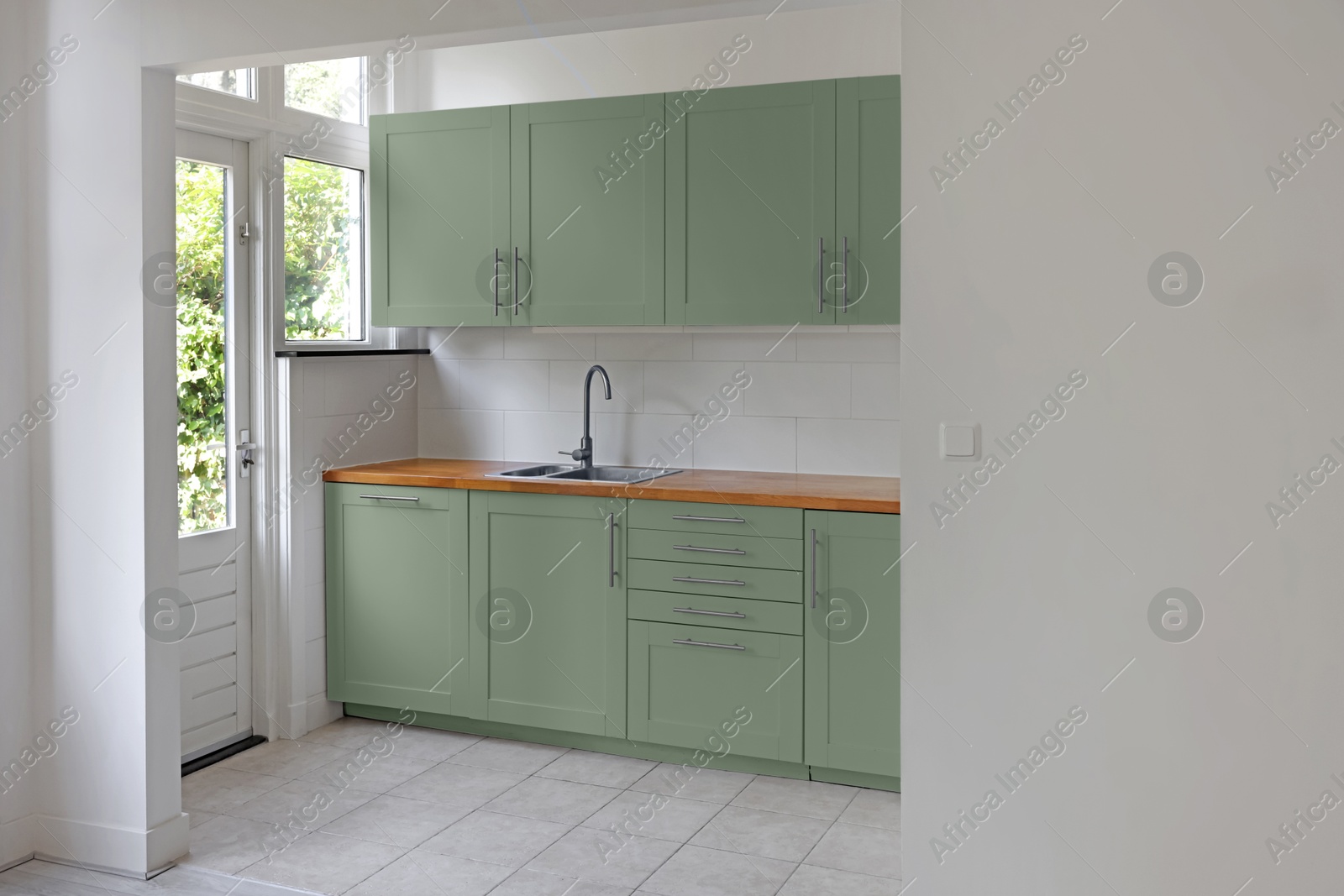 Image of Stylish sage green furniture in kitchen. Interior design