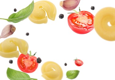 Raw pasta, tomatoes, garlic and basil in air on white background