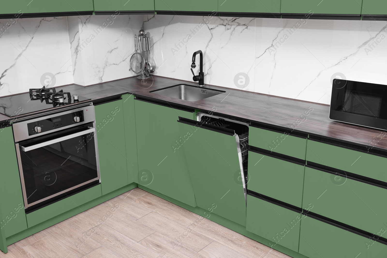 Image of Stylish sage green furniture in kitchen. Interior design