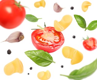 Raw pasta, tomatoes, garlic and basil in air on white background