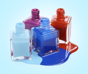 Image of Different nail polishes and open bottles on light blue background