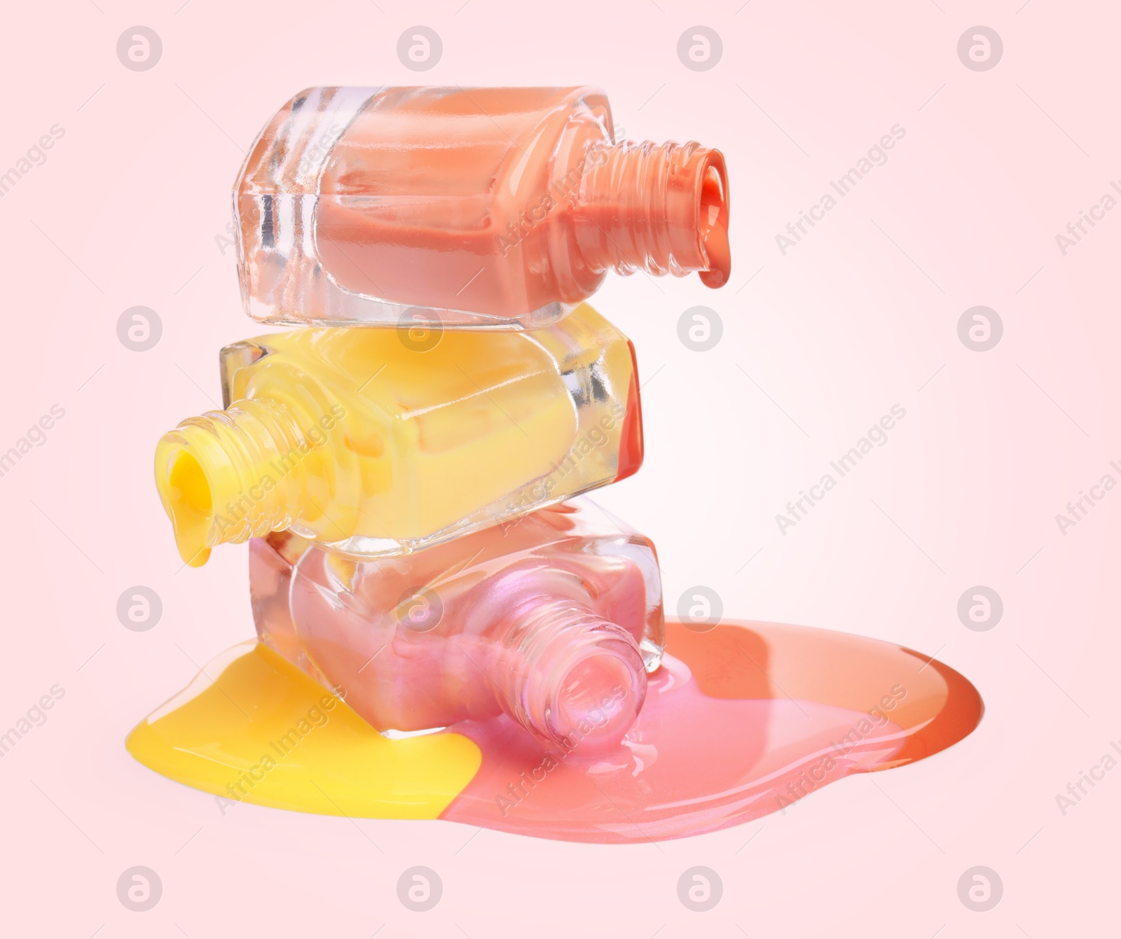 Image of Different nail polishes dripping from open bottles on light background