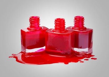 Red nail polish in bottles on light grey background