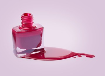 Image of Spilled red nail polish and bottle on light background. Space for text