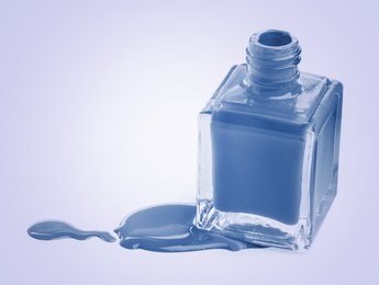 Image of Spilled blue nail polish and bottle on light background