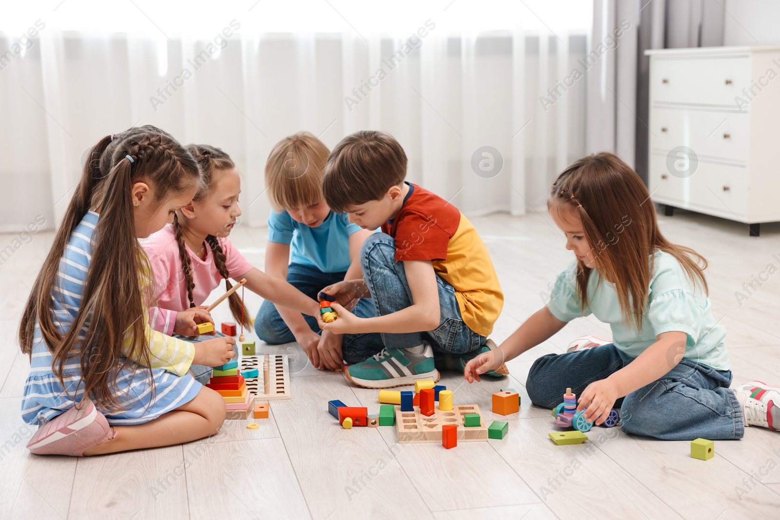 Photo of Group of children playing together on floor indoors