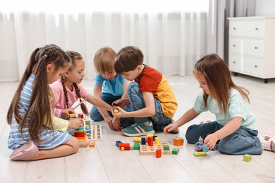 Photo of Group of children playing together on floor indoors