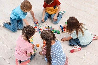 Photo of Group of children playing together on floor indoors