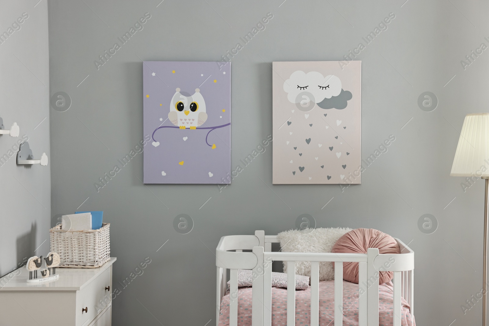 Photo of Newborn baby room interior with stylish furniture, comfortable crib and pictures of on wall