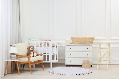 Newborn baby room interior with stylish furniture and comfortable crib