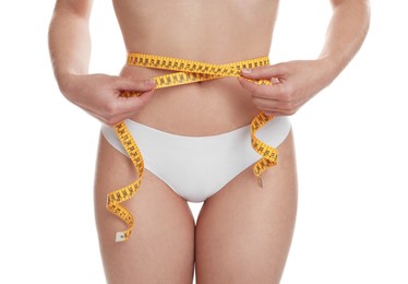 Photo of Woman with measuring tape showing her slim body against white background, closeup
