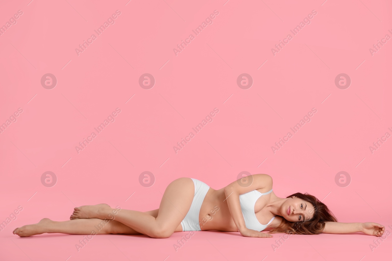 Photo of Woman with slim body posing on pink background, space for text