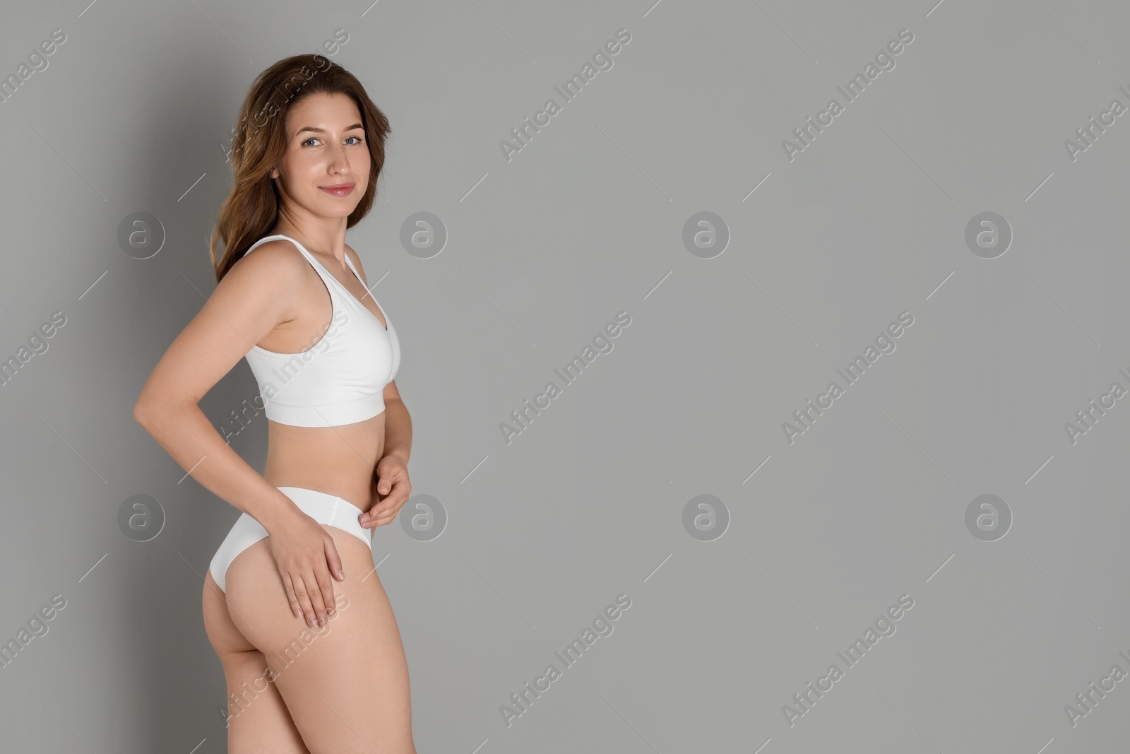 Photo of Woman with slim body posing on grey background, space for text