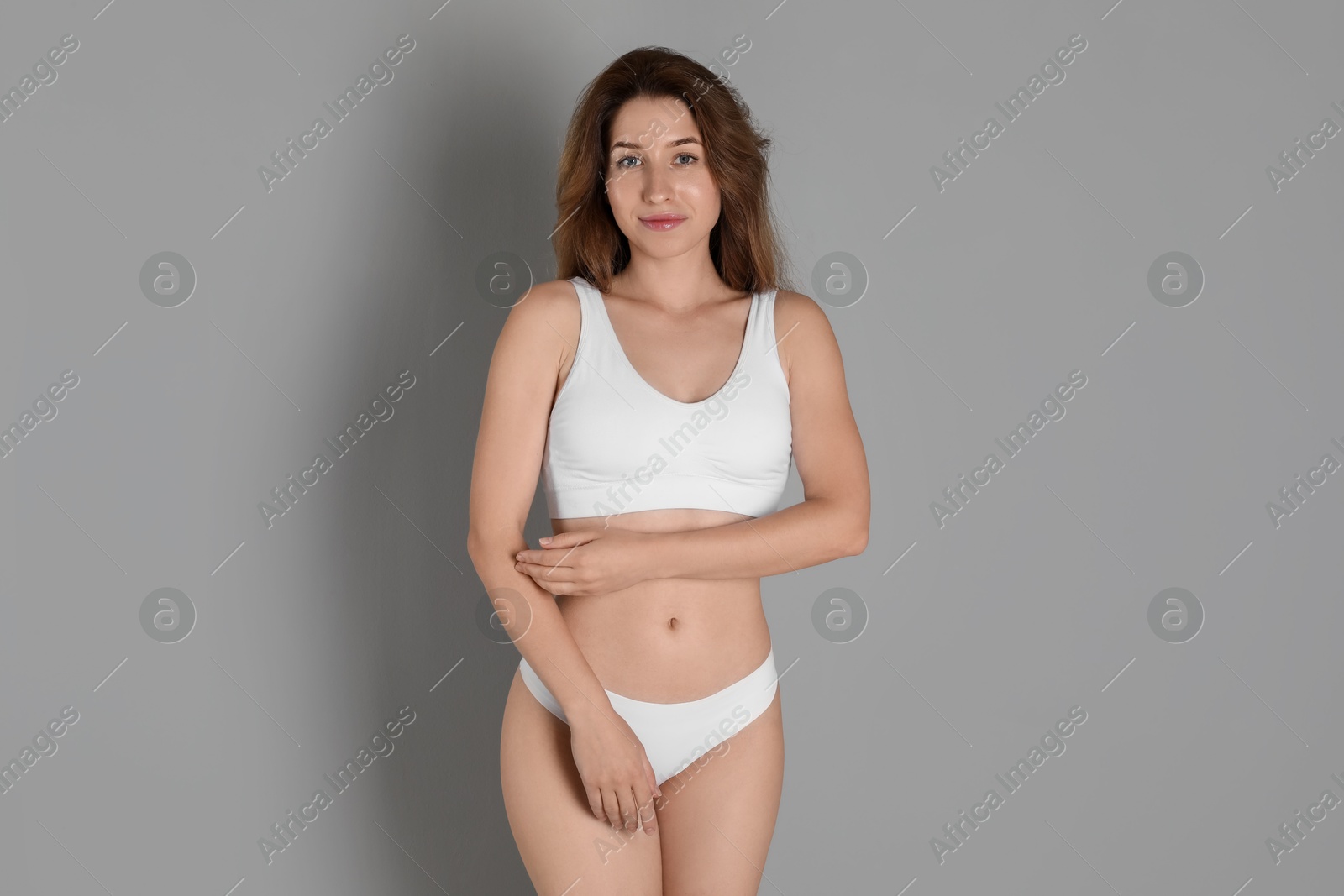 Photo of Woman with slim body posing on grey background