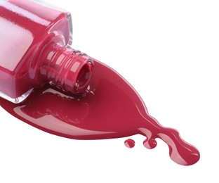 Bottle and spilled pink nail polish isolated on white