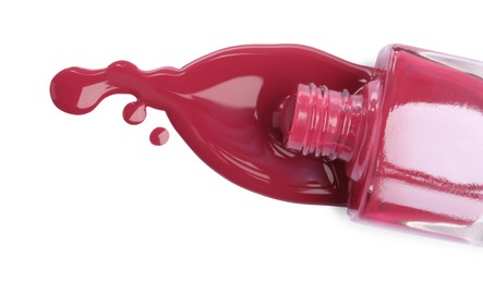 Bottle and spilled pink nail polish isolated on white, top view