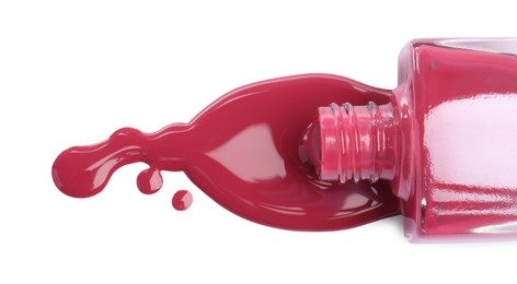 Bottle and spilled pink nail polish isolated on white, top view