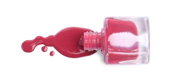 Bottle and spilled pink nail polish isolated on white, top view