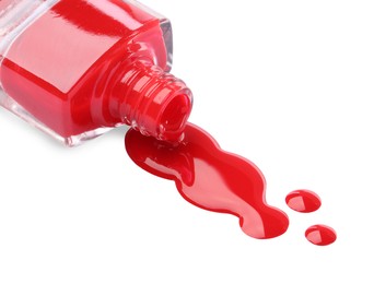 Photo of Bottle and spilled red nail polish isolated on white
