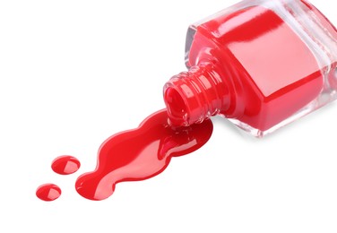 Bottle and spilled red nail polish isolated on white