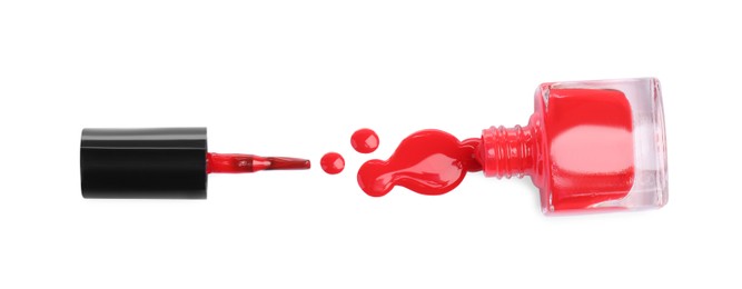 Photo of Bottle, brush and spilled red nail polish isolated on white, top view