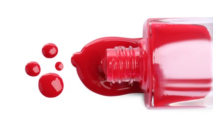 Bottle and spilled red nail polish isolated on white, top view