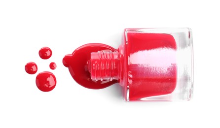 Bottle and spilled red nail polish isolated on white, top view