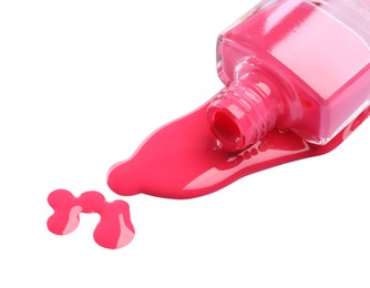 Bottle and spilled pink nail polish isolated on white