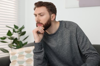 Photo of Loneliness concept. Sad man sitting on sofa at home