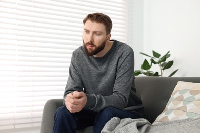 Photo of Loneliness concept. Sad man sitting on sofa at home