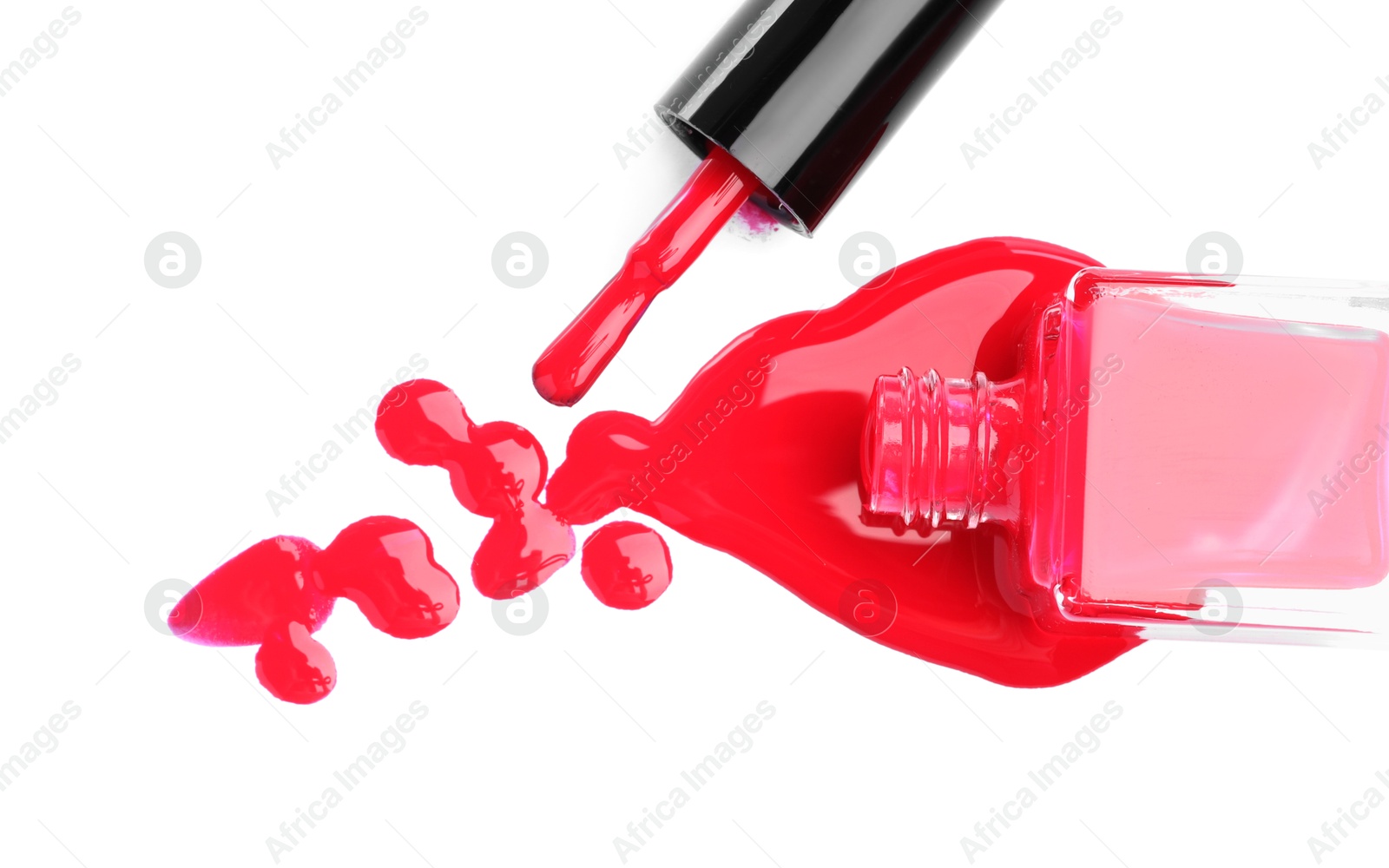 Photo of Overturned bottle of bright nail polish and brush isolated on white, top view