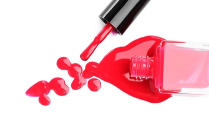 Overturned bottle of bright nail polish and brush isolated on white, top view