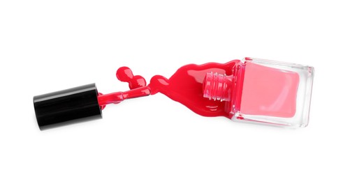 Overturned bottle of bright nail polish and brush isolated on white, top view