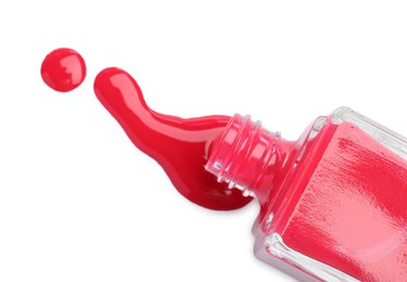 Photo of Overturned bottle of bright nail polish isolated on white, top view