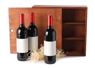 Photo of Wooden gift box with wine bottles isolated on white