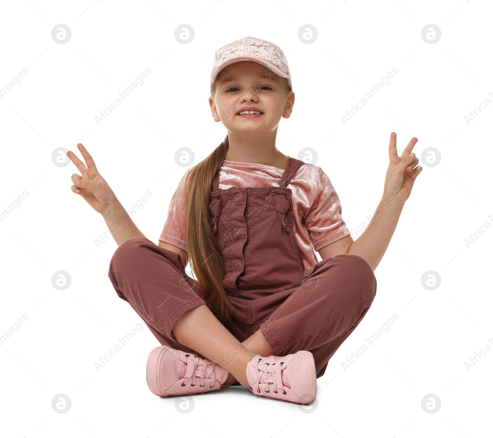 Photo of Cute little dancer showing V-sign on white background