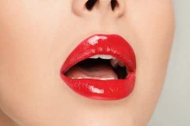 Woman with red lipstick on light background, closeup