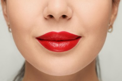 Woman with red lipstick on light background, closeup