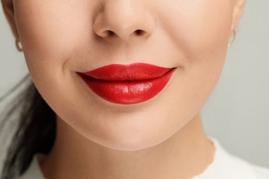 Woman with red lipstick on light background, closeup