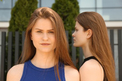 Two beautiful twin sisters outdoors, selective focus