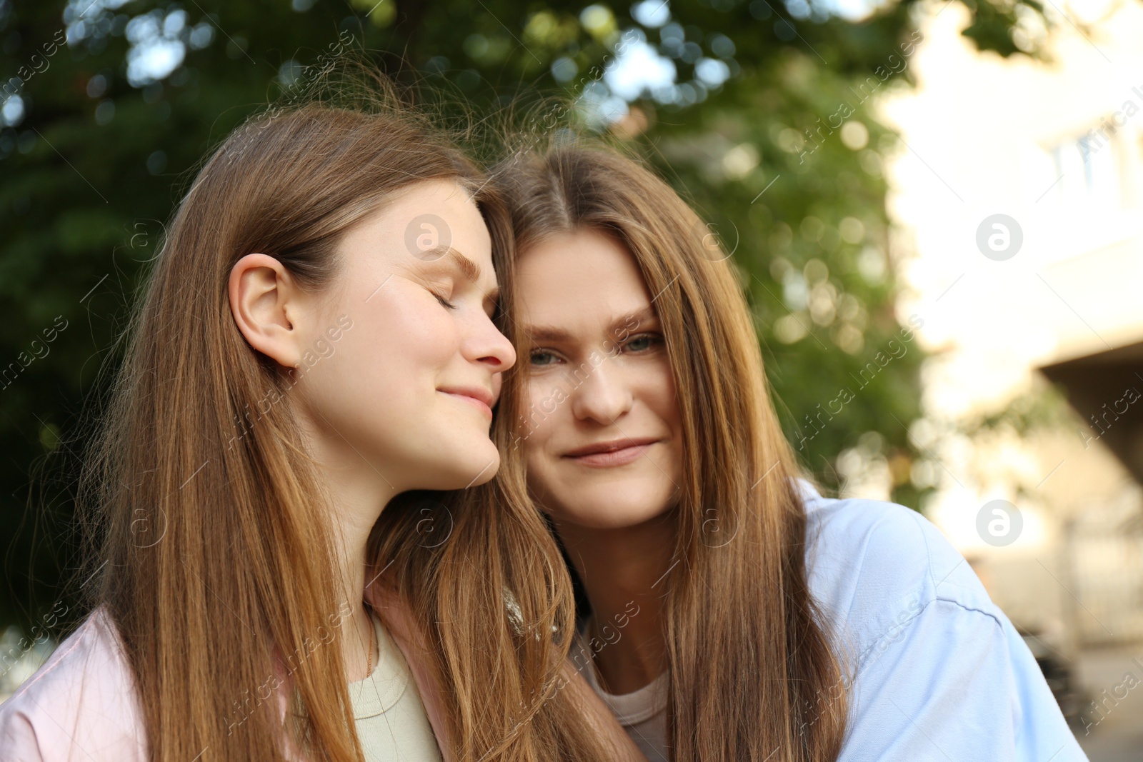 Photo of Portrait of two beautiful twin sisters outdoors